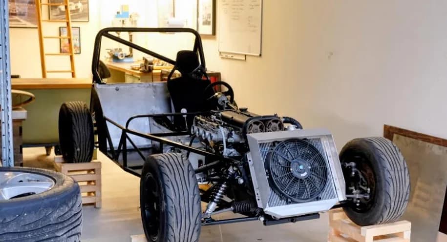 Chassis in de garage van de vorige eigenaar. Motor gemonteerd, koelblok op zijn plek, wielen op houten kratten aan weerszijden.