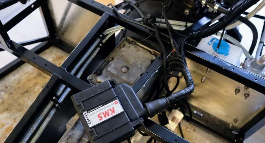 KMS MP-25 ECU gemonteerd tussen de chassisbuizen, met stuur- en aansluitkabels.