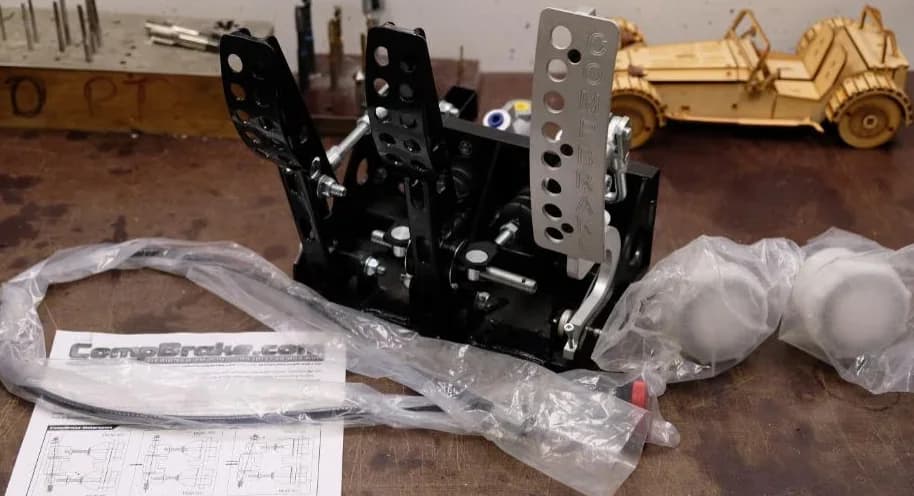 Nieuwe Compbrake staande pedalbox op de werkbank. Op de achtergrond een houten Seven-model.