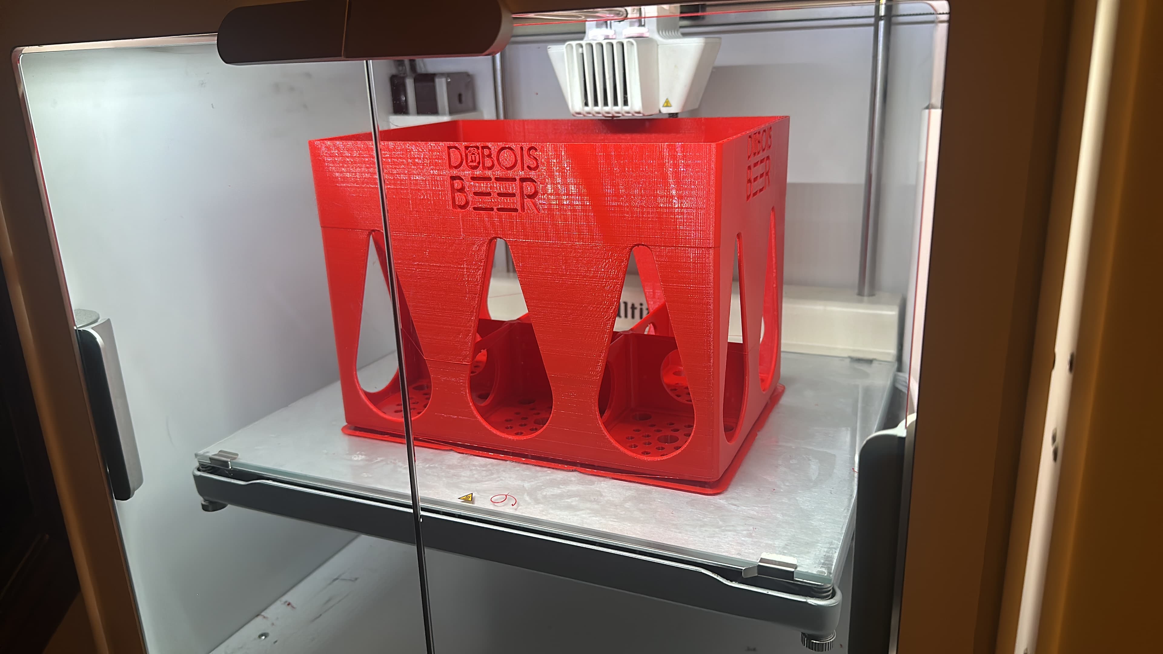 Rood bierbakje met DUBOIS BEER logo, tijdens het printen op de Ultimaker